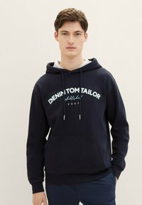 Felpa con cappuccio blu navy realizzata in morbido tessuto, con ampio tascone frontale, cappuccio con cordino e logo stampato in bianco con dettagli in turchese.