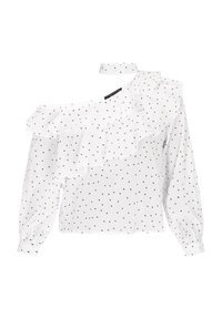 Weiße Bluse mit schwarzen Punkten, fransig an einer Schulter, langärmlig mit Puffärmeln und hohem Kragen. Leichter Stoff.