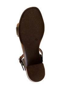 Bruine sandaalzool met een gestructureerde afwerking, voorzien van een brede voorkantstrap en een slanker enkelbandje met een metalen gesp.