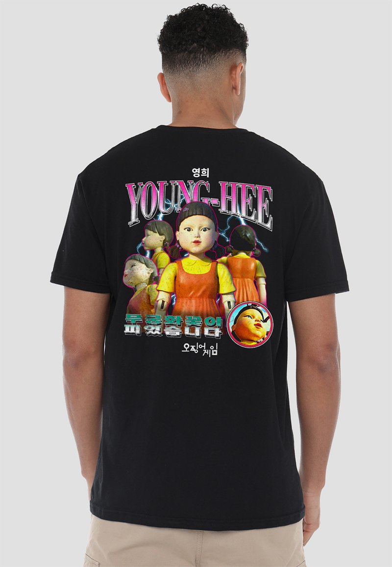 Black cotton t-shirt featuring a graphic print of a doll with text "YOUNG-HEE" in bold, colorful letters on the back.