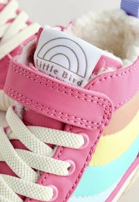 Rosa High-Top-Sneakers mit gummierter Sohle, ausgestattet mit einem bunten gestreiften Design und weißen Schnürsenkeln. Weiche, flauschige Innenauskleidung und sichtbares Markenetikett.