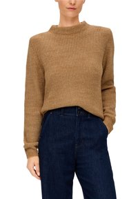 Sweter w kolorze kamelowym z prążkowanym wzorem, z wysokim kołnierzem i długimi rękawami, w połączeniu z ciemnoniebieskimi dżinsami o klasycznym kroju.