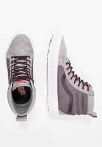 Wysokie trampki z szarego zamszu i siateczki z czerwonymi i czarnymi sznurówkami, z białą podeszwą i beżową gumową podeszwą. Detale z kontrastowym przeszyciem.