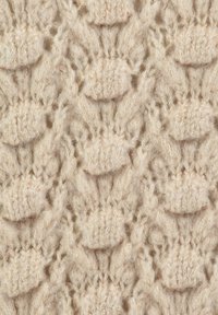 Helle beige gestrickte Stoffe mit einem strukturierten Muster und erhöhten Maschen. Weiche Fasern mit einem subtilen Glanz durch metallische Fäden.