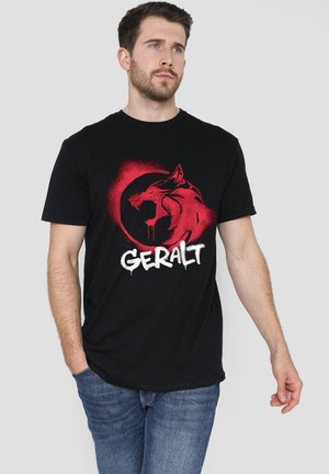 Schwarzes Baumwoll-T-Shirt mit einer rot-weißen Grafik eines Wolfs und dem Namen "Geralt" in stilisiertem Text. Klassisches Rundhalsausschnitt-Design.