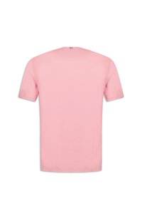T-shirt rosa a maniche corte in cotone. Caratterizzato da un collo rotondo e da un piccolo accento con la bandiera francese sul collo posteriore. Texture morbida.