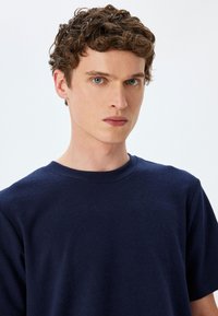 Mørkeblå bomulds t-shirt med korte ærmer og rund halsudskæring, med en blød tekstur og minimale syninger.