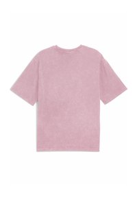 Maglietta rosa oversize con maniche corte e scollatura a girocollo. Tessuto morbido e testurizzato con una finitura leggermente vissuta. Nessun logo visibile.