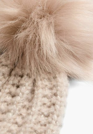 Kootud beanie heledas beežis, millel on pehme ja kohevam roosa pom-pom peal; sellel on tekstuuriline muster, millel on õrnad sädelused kogu ulatuses.