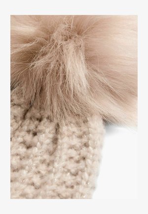 Kootud beanie heledas beežis, millel on pehme ja kohevam roosa pom-pom peal; sellel on tekstuuriline muster, millel on õrnad sädelused kogu ulatuses.