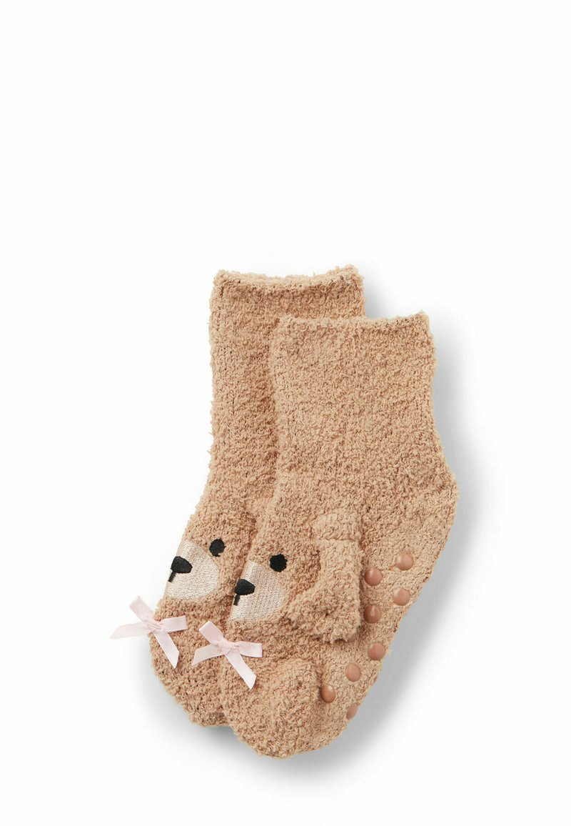 Calzini fuzzy beige con un design a forma di faccia di cane, caratteristiche ricamate nere e fiocchi rosa alla caviglia; punti in silicone antiscivolo nelle suole.