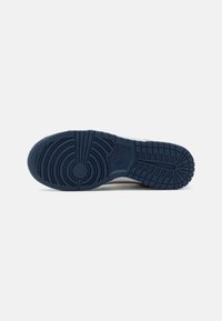 Sola di sneaker in gomma blu navy con un motivo di battistrada testurizzato, design circolari e lineari, e un piccolo logo impresso nell'area del meso.