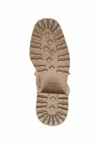 Suela de goma beige con un patrón de banda de rodadura resistente, que presenta formas de cruz y rectángulo, etiquetada "ALMA EN PENA" y talla "37."
