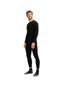 Zwart langhandig thermoshirt en legging set, lichte stof, slim fit design, met grijze accent sokken, geschikt voor laagjes of activewear.