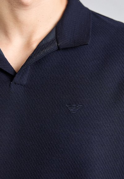 Námořnická polo košile s texturovaným ribovaným vzorem, s límečkem a výšivkou loga na levé hrudi.