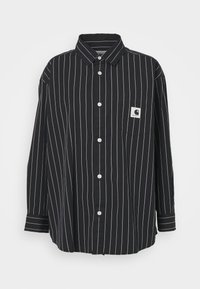 Camisa de manga larga a rayas blancas y negras con cuello, botones en la parte delantera y un bolsillo en el pecho izquierdo que presenta un parche de logo. Material de algodón.