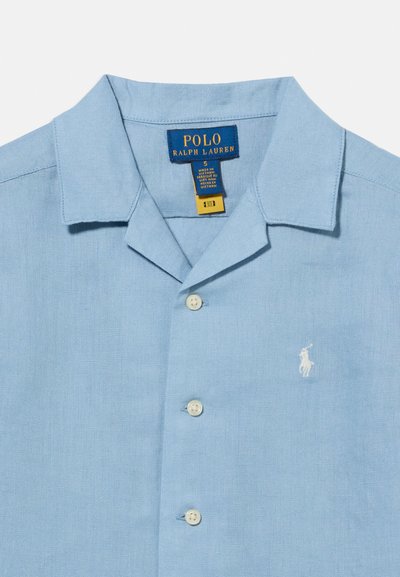 Ανοιχτό μπλε πουκάμισο με γιακά και κουμπιά, με λευκό λογότυπο Polo Ralph Lauren στο αριστερό στήθος και ετικέτα της μάρκας στο εσωτερικό του γιακά.