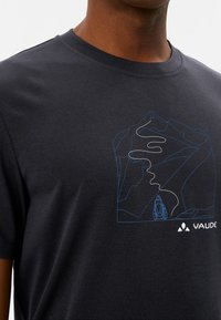 Korte mouwen, donkergrijze t-shirt met een blauwe berggrafiek en padontwerp. Bevat het Vaude-logo rechtsonder.