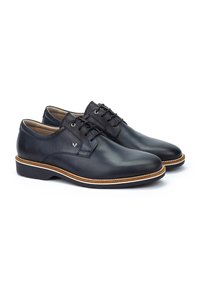 Chaussures habillées en cuir noir avec une finition lisse, bout rond, lacets et semelle beige clair. Présente un minimum de coutures et un détail de logo.