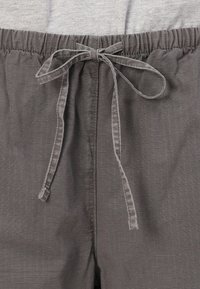 Shorts gris avec une taille élastique et un cordon de serrage. Le tissu présente un motif rayé subtil et une texture lisse.