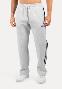 Grijze sweatpants met een zachte textuur, voorzien van zwarte zijstrepen, een elastische tailleband met aantrekkoord, en zijzakken.