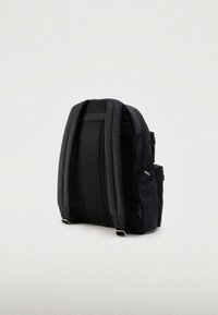 Svart ryggsekk med polstrede skulderstropper, nettpanel på baksiden og sidelommer. Har en glatt tekstur i stoffet og et minimalistisk design.