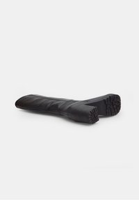 Bota negra de cuero hasta la rodilla con textura lisa, punta redondeada y suela de goma con dibujo para mayor tracción.