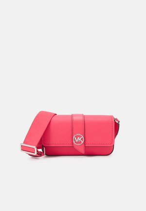 Bolso cruzado de cuero rosa con cierre de solapa, logotipo MK en plata, correa ajustable y textura suave. Forma rectangular compacta.