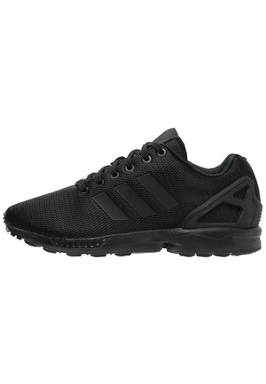 Baskets de sport noires avec dessus en mesh, fermeture à lacets, trois bandes latérales, et renfort moulé au talon, vues de profil.