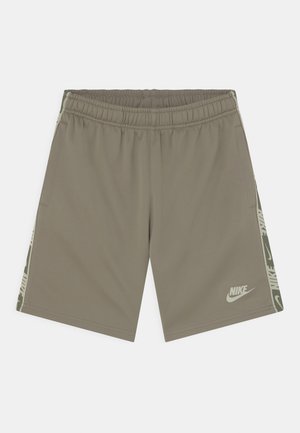 Jasnobrązowe sportowe spodenki Nike z elastycznym pasem, bocznymi kieszeniami i charakterystycznymi paskami po bokach.