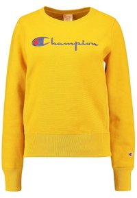 Felpa gialla in cotone con collo a giro, polsini e orlo ribattuti, con il logo "Champion" ricamato in blu e rosso.