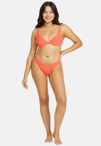 Conjunto de bikini de color coral con costuras acanaladas, que incluye un sujetador con detalle de frente retorcido y una parte inferior de talle alto a juego. Textura suave con tirantes ajustables.