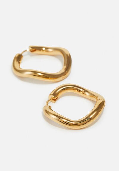 Goldfarbene Creolen mit einer glatten, runden Form und einem gedrehten Design. Sie verfügen über einen sicheren Klappverschluss und eine polierte Oberfläche.