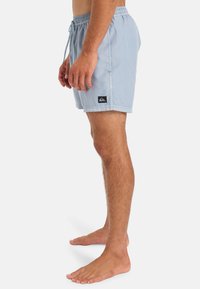 Svetle modré plavky s elastickým pasem a šňůrkou na stažení. Na boku mají černou nášivku s logem. Měkká, lehká tkanina.