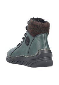 Zielony skórzany botek za kostkę z brązowym dzianym mankietem, teksturowaną powierzchnią, czarnymi sznurowadłami, okrągłym logo po boku oraz gumową podeszwą.