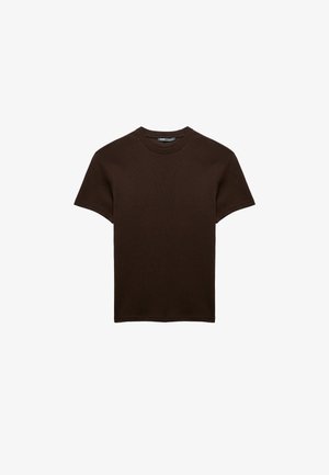 Ruskea lyhythihainen t-paita ribbikankaasta, jossa on pyöreä pääntie ja rento istuvuus. Ei grafiikoita tai kuvioita.