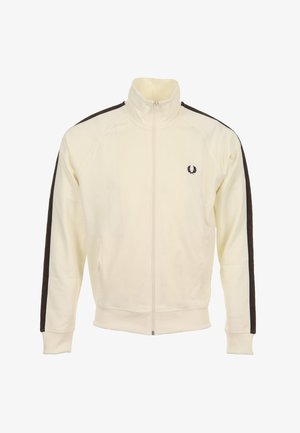 Beige jas met rits en hoge kraag, met donkerbruine strepen aan de zijkant en een klein geborduurd logo op de borst. Zachte stof, atletische pasvorm.