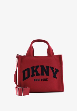 Sac fourre-tout rouge avec poignées courtes et bandoulière ajustable, arborant un texte noir audacieux "DKNY NEW YORK" à l'avant.