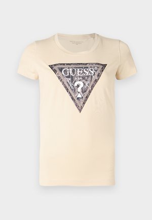 T-shirt color crema con un logo triangolare nero e argento stampato al centro, con un dettaglio a forma di punto interrogativo. Materiale in cotone morbido.