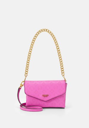 Sac à main Guess rose vif avec logos embossés, poignée chaîne dorée et bandoulière rose amovible, sur fond blanc.