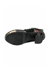 Sole delle scarpe nera con motivo floreale e grip testurizzato. La parte superiore presenta disegni floreali multicolori e accenti geometrici su una superficie liscia.