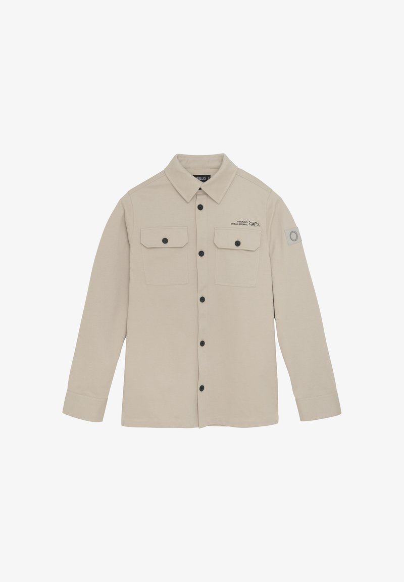 Beige langærmet skjorte lavet af struktureret stof, med knaplukning foran, to brystlommer og et patch på venstre arm.