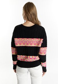 Pulover negru din tricot cu model împletit, având motive geometrice îndrăznețe în dungi roz, galbene și mov pe mijloc și pe mâneci.