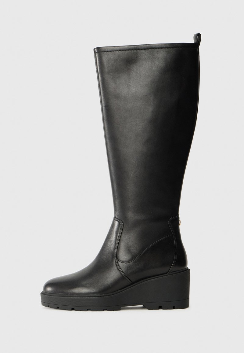 Botte noire en cuir montant, avec une semelle compensée, une texture lisse, un design sans coutures et une petite languette en haut pour un enfilage facile.