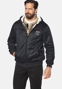 Men's black fleece-lined jacket with a zip closure, ribbed cuffs, front pockets, and a patch featuring a mountain design.