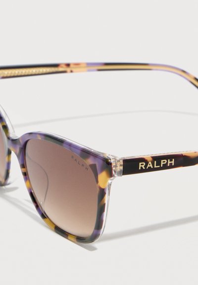 Γυαλιά ηλίου Ralph με σχέδιο καβουρόφρακτο, φακούς με καφέ διαβάθμιση και χρυσά γράμματα "RALPH" στους βραχίονες.