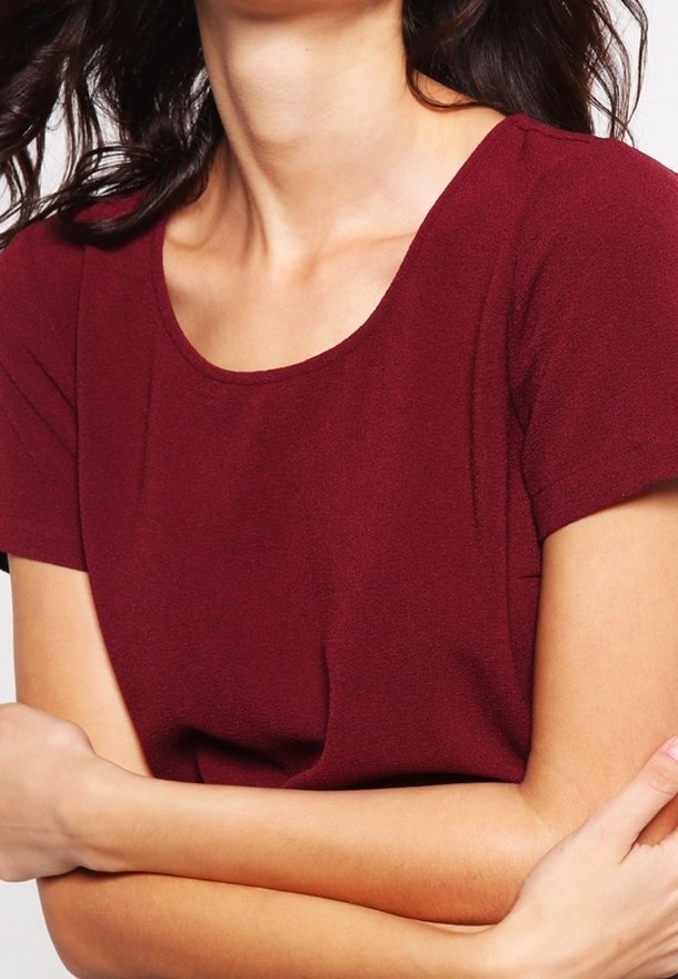 Haut bordeaux à manches courtes avec un col rond, confectionné dans un tissu doux et texturé. Présente une silhouette ajustée et un minimum de détails.