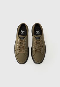 Olivengrønne lærremsneakers med sorte gummisåler og metalliske snørehuller. Har runde snørebånd og polstret krave for komfort.