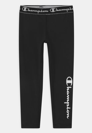 Zwarte leggings gemaakt van rekbaar materiaal, met een brede tailleband met het "Champion"-logo en een wit logo gedrukt op het linkerbeen.
