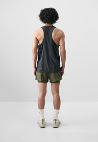 Dark gray sleeveless tank top, olive green shorts, white socks, and beige shoes. Simple design, smooth texture, and relaxed fit.